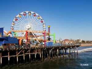a ferris wheel on a pier with Santa Monica Pier in the background